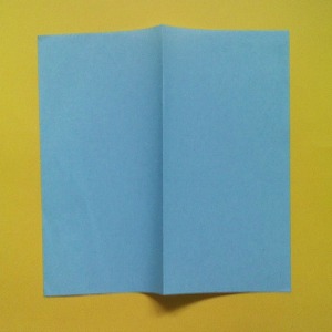 Take a square piece of paper of approximate size 6 inches square.  Make a mountain fold in the center as shown in the photo and make a sharp crease in the paper.
