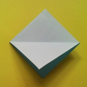 Fold diagonally the top flap of the square fold as shown. Fold diagonally the top flap of the square fold as shown.
